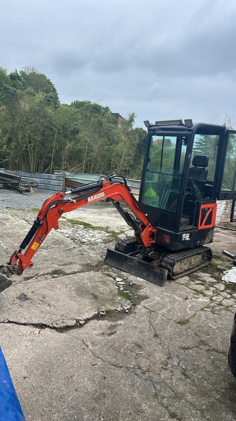 Miniexcavadora naranja en obra exterior
